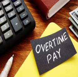Overtime pay written on a piece of black paper