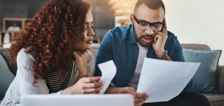 Two people looking at bills