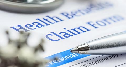 Close up of a health benefits claim form and a pen.