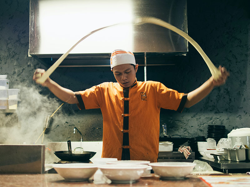 Cook making dough in Asian restaurant