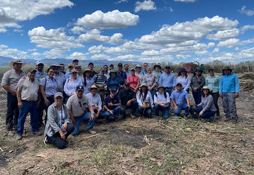 A group of people, including ILAB staff and our partners, pose for a group photo in an open field in El Salvador as part of a data collection trip.