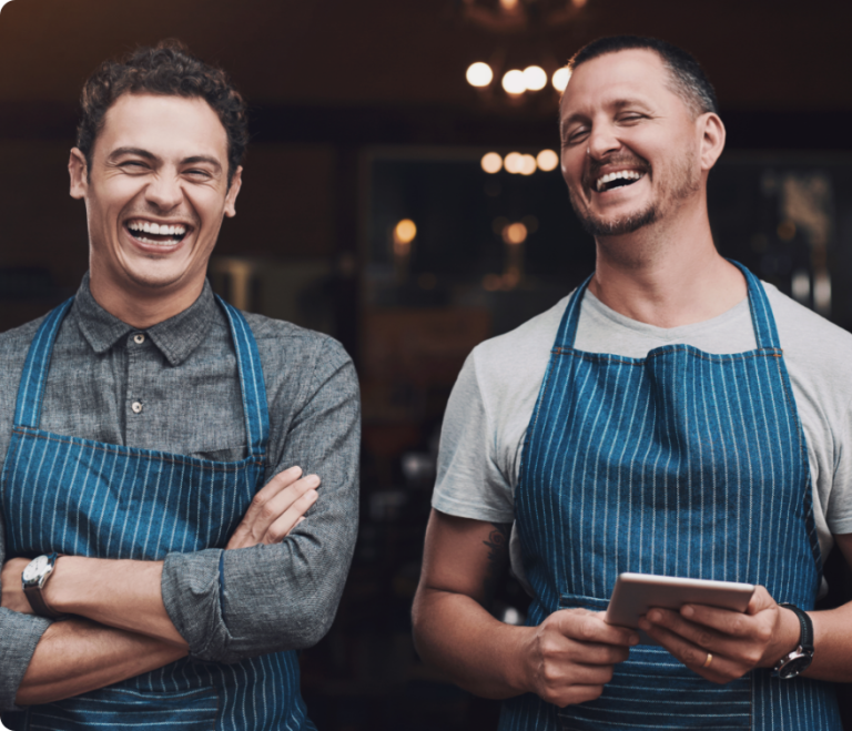 Two cafe employees standing in front of a business.