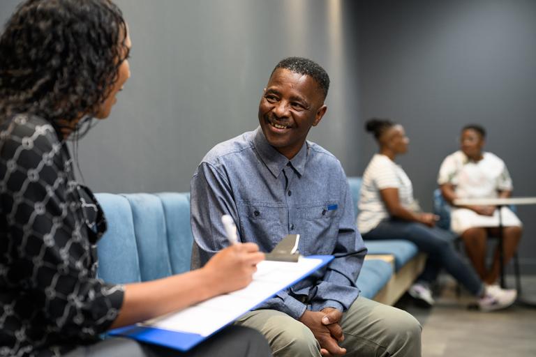 Man sitting and swilling at woman