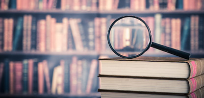 magnifying glass on top of books