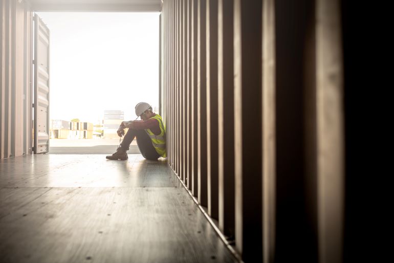 Link to TAA Termination Fact Sheet.  Image of worker sitting in a shipping container.