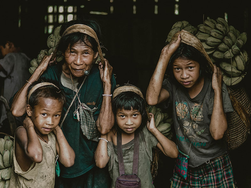 Older woman and children carrying bananas, child labor.  Bongabong, Oriental Mindoro, Philippines