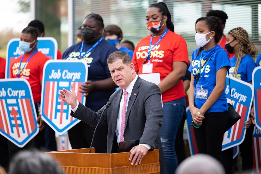 Secretary of Labor Marty Walsh with a group of people holding "Job Corps" signs.