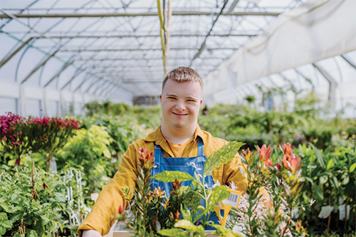 A person with Down syndrome working in a greenhouse