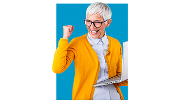 older woman clenching her fist in excitement and holding a laptop computer