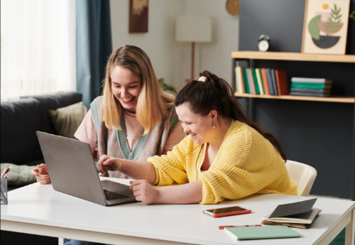 Two woman sit in front of the labtop