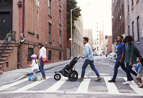 Family walking down a city street with a stroller