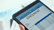A person holds a tablet on which the words “medical billing statement” are visible. Below that is a neatly labeled chart. 