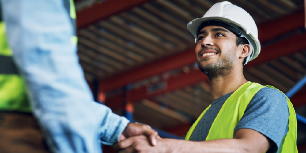 Two construction workers shaking hands.