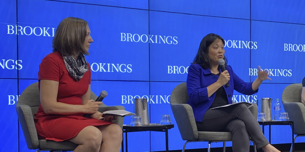 Deputy Secretary Julie Su speaks on a stage in front of a backdrop reading Brookings.