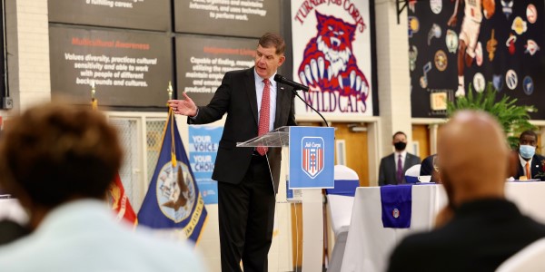 U.S. Labor Secretary Marty Walsh speaks from a podium to a listening audience. 