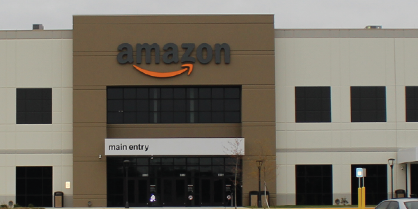 Exterior of an Amazon facility. The company’s logo is above the main entrance. Photo by Michael Rivera. License: Creative Commons Attribution-Share Alike 4.0.