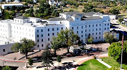 Department of Veterans Affairs aerial photo of the medical center in Prescott, Arizona, which is a large, multi-story white building.