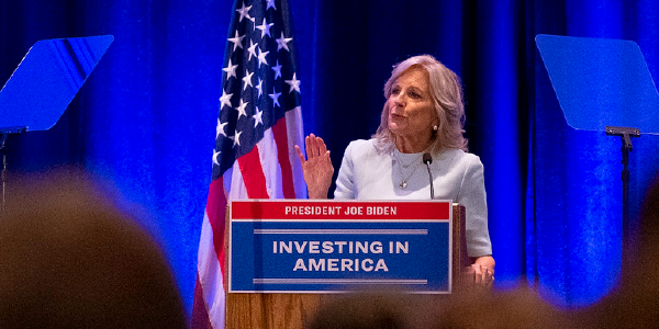 First Lady Jill Biden speaks at a podium bearing a sign that says 