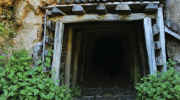 An entrance to an abandoned mine in the side of a rock formation. The tunnel leads to an underground coal mine. 