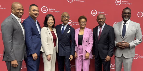Acting Secretary Su poses for a photo with the Rev. Al Sharpton and five other National Urban League representatives.