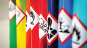 A row of colorful canisters, each baring hazard warning labels.