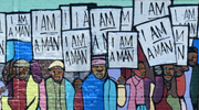 Colorful mural recreating a 1968 photograph of Black workers in Memphis holding signs that read “I am a man.” Source: Ilse Orsel, Unsplash
