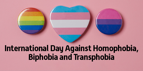 International Day against homophobia, biphobia and transphobia. Text appears below pins bearing flag colors associated with LGBTQI+ pride.