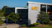 Exterior of an academic building on the Albany State University campus. Green trees are in front and the letters ASU appear on the side.  