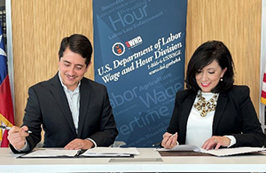 Betty Campbell, Regional Administrator for the Wage and Hour Division in the Southwest and Travis County District Attorney José P. Garza, sign a Memorandum of Understanding to expand and improve the protections of Travis County workforce.