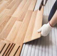A person laying floor boards