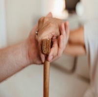 a person assisting someone with their cane