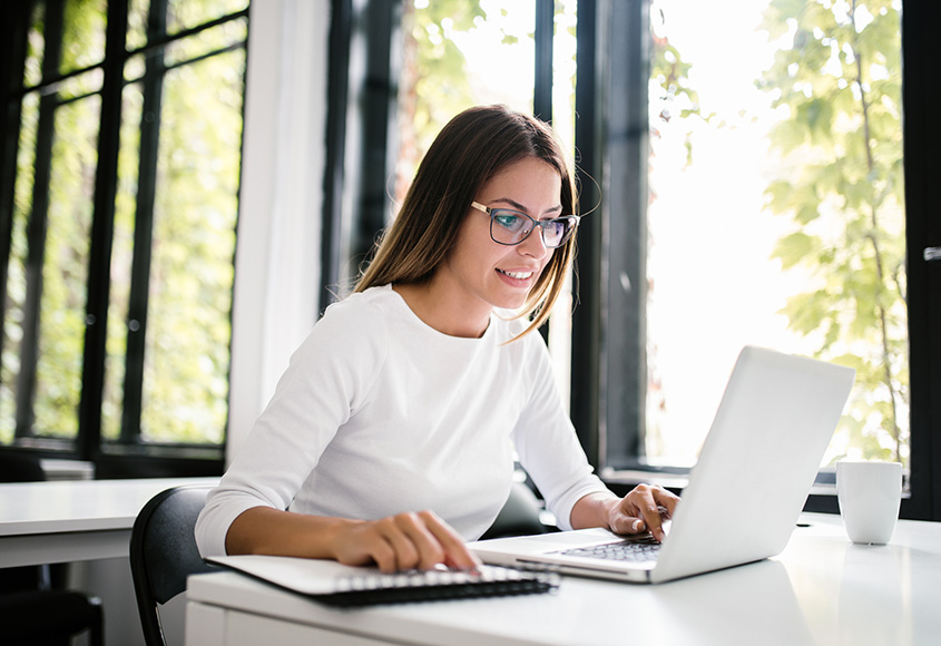Woman working on her laptop in a cafe. 