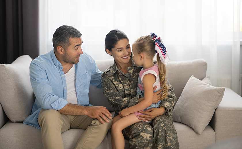 Woman Veteran with husband and daughter sitting on couch