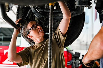 A female mechanic working under a car