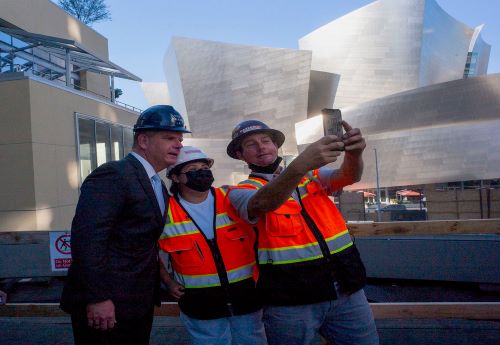 Secretary of Labor Marty Walsh taking a selfie with two construction workers