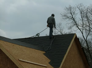 Worker on a roof using fall protection.