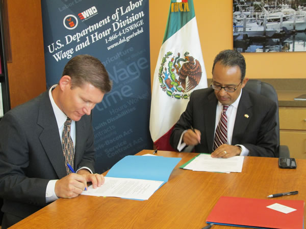 R. Casey Perkins (left) area director in Austin for the U.S. Department of Labor's Occupational Safety and Health Administration signs alliance with Carlos Gonzalez Gutierrez (right) consul general for the Mexican Consulate in Austin.