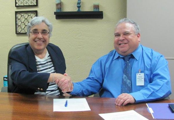 Margaret Arreola, David L. Carrasco Job Corps Center director (left) and Diego Alvarado Jr., OSHA area director in El Paso (right) sign the alliance agreement at the Job Corps center in El Paso.