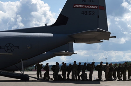Military personnel boarding a transport plane. 