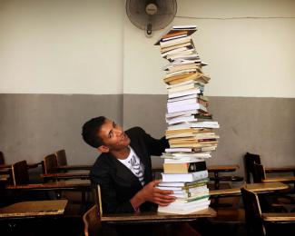 Mahmoud at a desk with books. Photo by Chris de Bode.